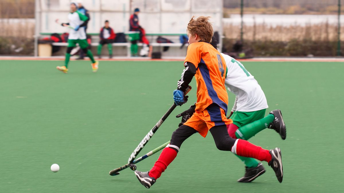 Two boys hockey players complete for the ball.