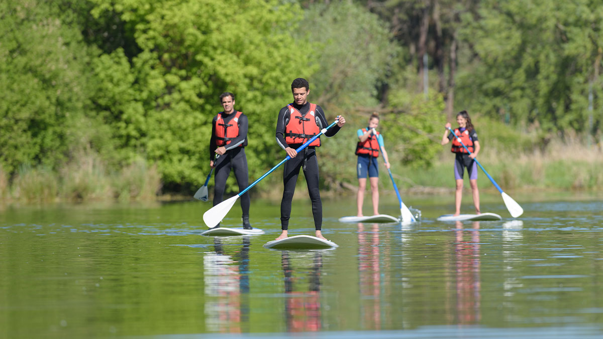 Group of people stand up paddleboarding