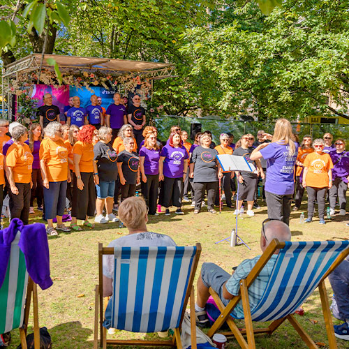 Choir singing outside with the audience on beach chairs