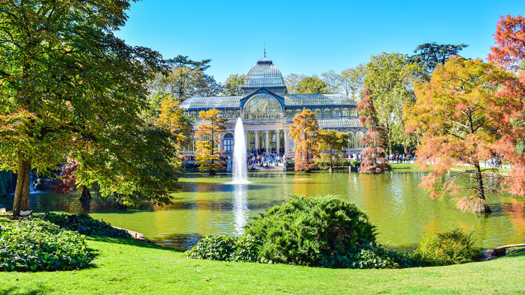 Palacio de cristal en Madrid, EspaÃ±a. Crystal palace in Madrid, Spain, covered by nature and just a beautiful landscape in the summer/fall season on the year